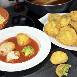 Coliflor capeada sin harina, rellena de queso, servida con caldillo rojo. Receta baja en carbohidratos, perfecta para dieta keto.